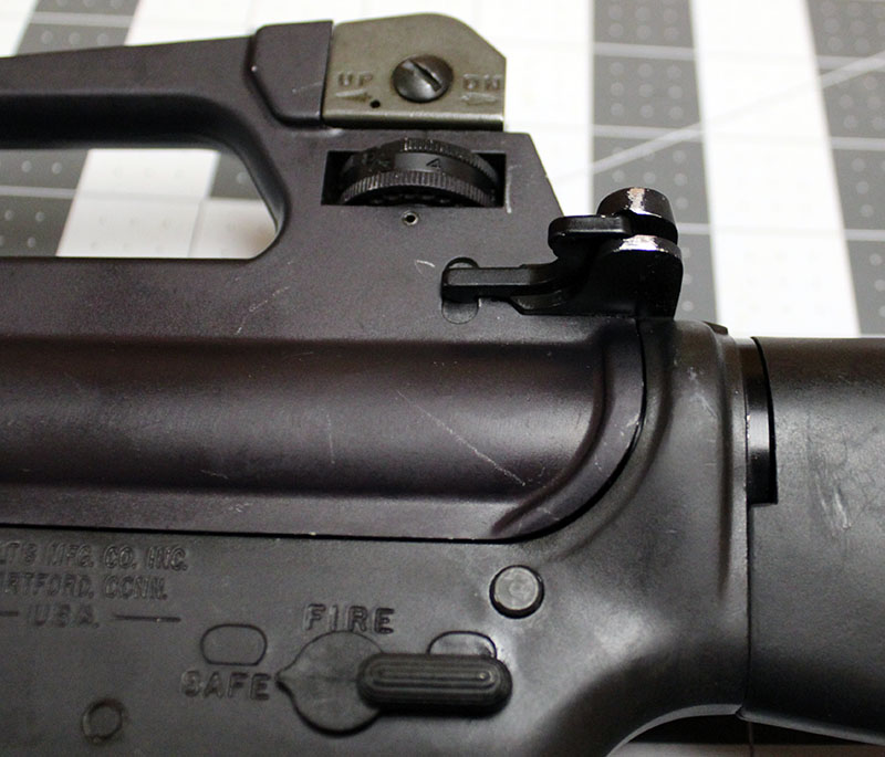detail of rear upper left receiver corner, with rear sight and charging handle latch
